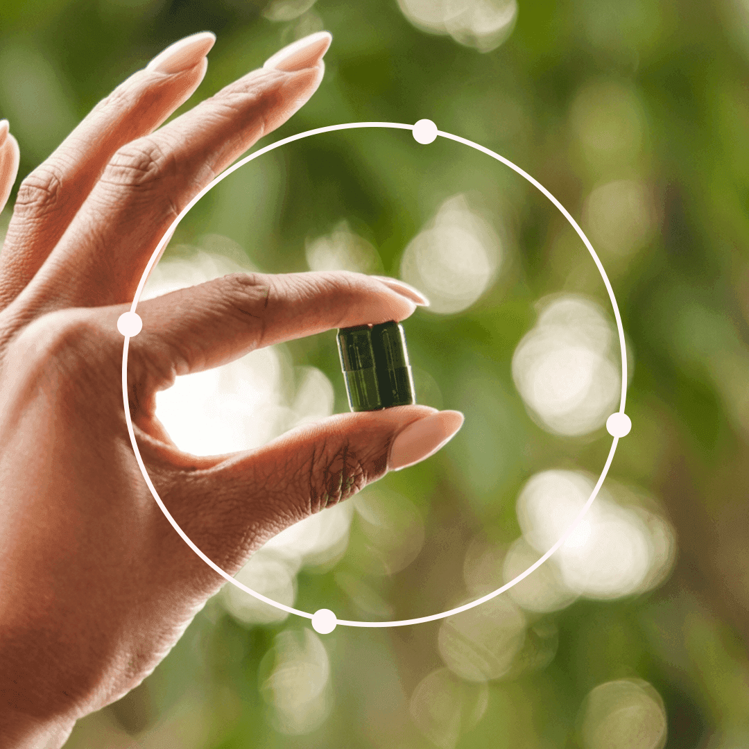 A hand holding a capsule