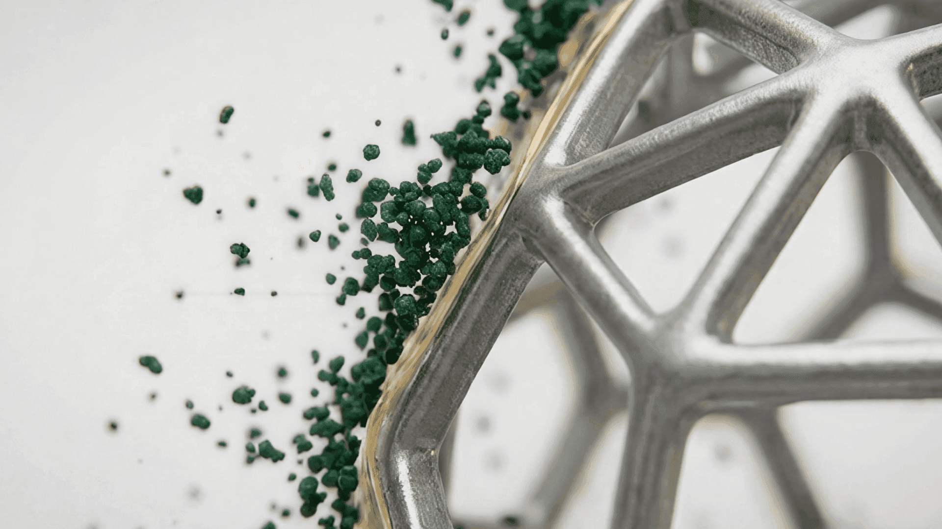Silver geodesic lattice sphere with green micronized granules spilling out